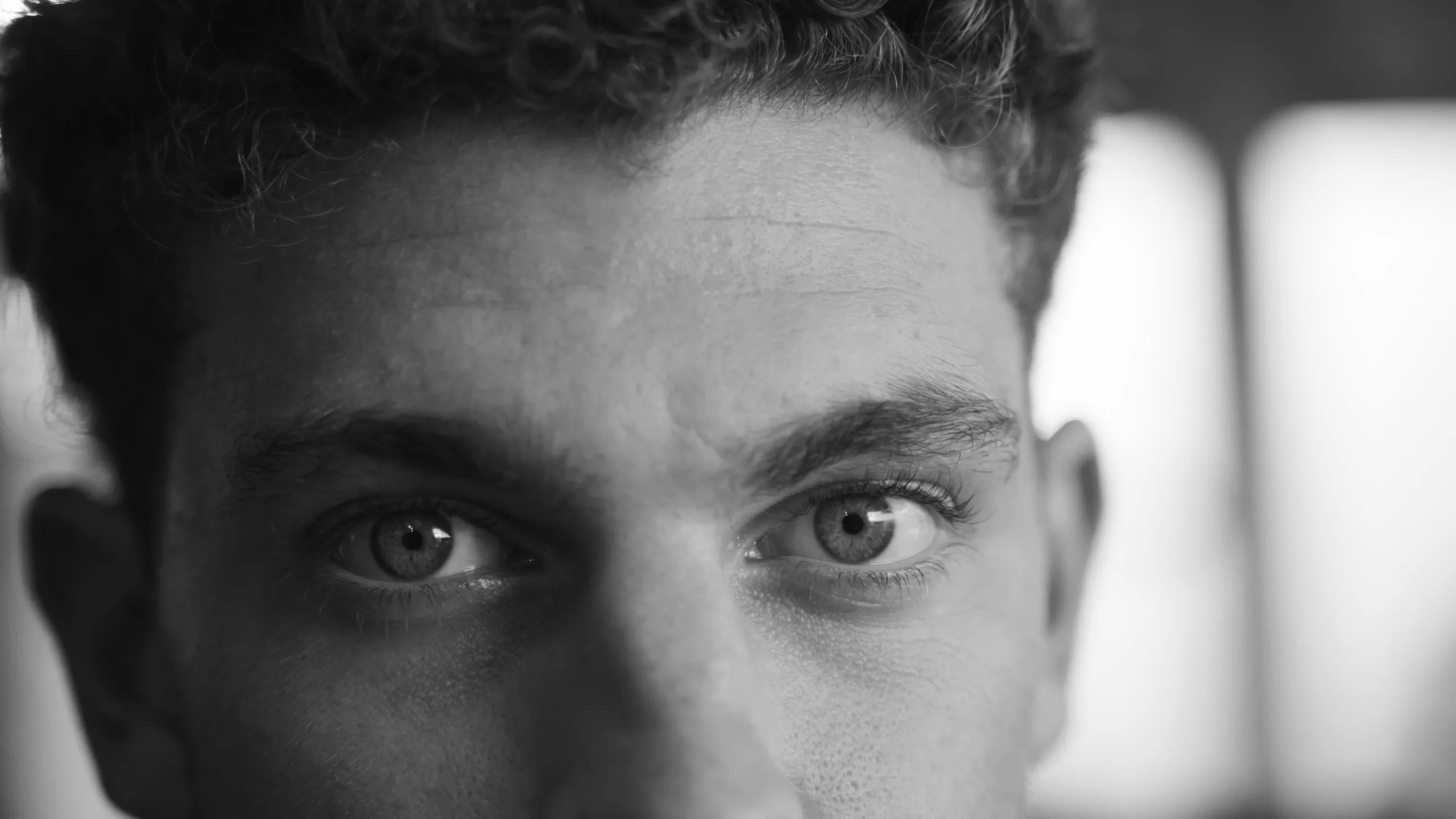 Maarten van Schijndel kijkt recht in de camera. Zwart-wit close-up van zijn gezicht.